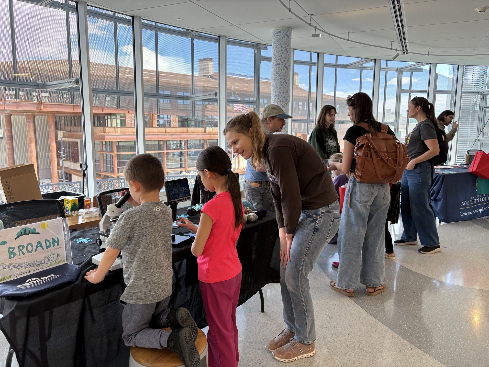 Showing a child pollen under a microscope at “Girls & Science” at Second Saturday at CSU Spur!